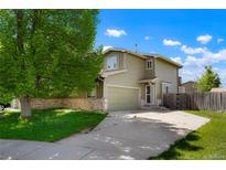 Charming two-story home with a well-manicured lawn and a spacious driveway on a sunny day at 5154 E 126Th Ct, Thornton, CO 80241