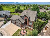 Gorgeous home boasts lush landscaping, mountain views, and an expansive lawn perfect for outdoor activities at 12693 W 82Nd Ln, Arvada, CO 80005