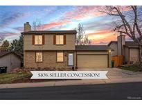 Charming two-story home with brick accents, garage and landscaped front yard under a vibrant sunset sky at 18093 E Milan Pl, Aurora, CO 80013