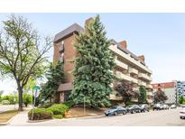 A lovely brick apartment building with mature trees and manicured landscaping at 4110 Hale Pkwy # 3K, Denver, CO 80220