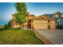 Charming two-story home featuring a well-manicured lawn and a three-car garage at 1820 Sapling Ct, Castle Rock, CO 80109