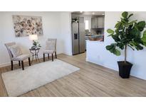 Bright and airy living room with modern flooring, art, and a view of the kitchen at 7956 Joan Dr, Denver, CO 80221