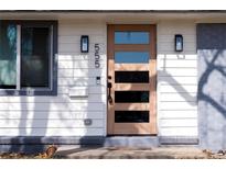 Modern front door with glass panes, sconces, and visible house number creates a welcoming entrance to this charming home at 555 W Peakview Ave, Littleton, CO 80120