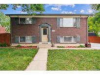Charming brick home with green shutters and a well-maintained front lawn and landscaped entrance at 11855 Humboldt Dr, Northglenn, CO 80233