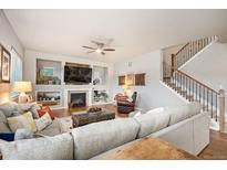 Comfortable living room with fireplace, tv, and staircase to the second level at 1788 Holmby Ct, Castle Rock, CO 80104
