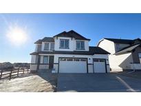 Striking two-story home with a three car garage, modern architectural details, and manicured front yard at 16805 Mckay Dr, Mead, CO 80542