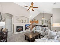 Cozy living room features a fireplace, TV, comfortable seating and high ceilings, perfect for relaxing and entertaining at 22610 E Ontario Dr # 204, Aurora, CO 80016