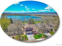 Stunning lakefront property with mountain views, a charming home, and lush greenery at 2590 W Long Cir, Littleton, CO 80120