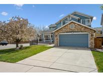 Two story home featuring stone accents and blue siding and a two car garage at 4290 Cottonwood Lakes Blvd, Thornton, CO 80241