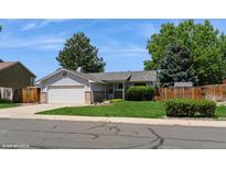 Charming ranch-style home featuring a well-maintained lawn and a two-car attached garage at 7325 S Houstoun Waring Cir, Littleton, CO 80120