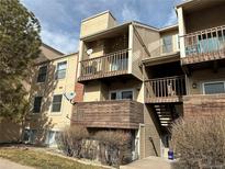 Tan two-story condo building with balconies and stairs at 15350 E Arizona Ave # 308, Aurora, CO 80017