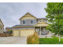 Charming two-story home with a well-maintained lawn, two car garage, and inviting front porch at 12981 E 108Th Way, Commerce City, CO 80022