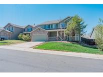 Charming two-story home with a well-manicured lawn and a welcoming front porch at 5149 S Tibet St, Aurora, CO 80015
