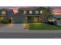 Charming two-story home with a well-manicured lawn and a two car garage during a beautiful twilight at 5149 S Tibet St, Aurora, CO 80015