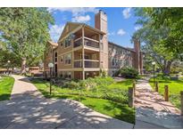 Attractive condo building showcasing balconies, mature trees, and well-manicured landscaping at 10950 W Florida Ave # 314, Lakewood, CO 80232