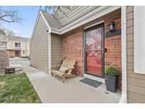 Charming front porch featuring a cozy wooden chair and a welcoming entrance with brick accents at 7476 E Arkansas Ave # 35-01, Denver, CO 80231
