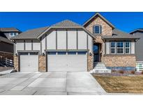 Inviting home exterior boasts a stone facade, three car garage, and meticulously maintained landscaping at 7031 S Undergrove Way, Aurora, CO 80016