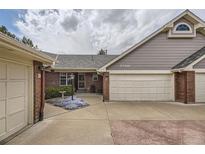 Charming home exterior featuring a two-car garage, brick accents, and well-maintained landscaping at 2700 W Riverwalk Cir # C, Littleton, CO 80123