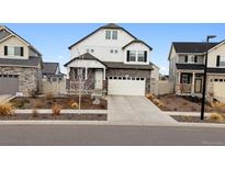 Charming two-story home with stone and siding, a two-car garage and landscaped front yard at 22025 E 45Th Ave, Aurora, CO 80019