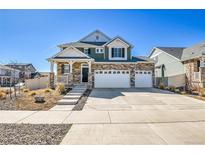 Inviting two-story home featuring stone accents, a spacious three-car garage, and landscaped front yard at 4407 N Quemoy St, Aurora, CO 80019