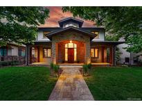 A welcoming two-story home features a stone entrance, covered porch, and well-manicured front yard at 1351 S Milwaukee St, Denver, CO 80210