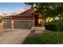 Charming home exterior featuring a two-car garage, stone accents, and a cozy front porch at 2746 Stallion Way, Mead, CO 80542