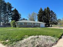 Charming single-story home with a well-maintained lawn, lovely trees, and an attached one-car garage at 6552 S Pearl St, Centennial, CO 80121