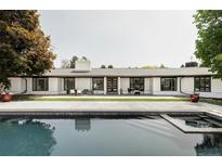 Stunning home exterior with a pool, white facade, and a well-manicured lawn, perfect for outdoor living and entertaining at 3801 S Albion St, Englewood, CO 80113