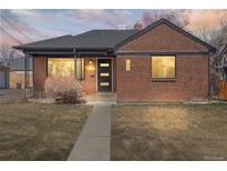 Charming brick home featuring a well-manicured lawn and a welcoming front porch at 2731 W 42Nd Ave, Denver, CO 80211