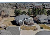 Expansive property featuring a well-maintained lawn, mature trees, and a home with a distinctive roofline in a suburban setting at 5284 Taft Ct, Arvada, CO 80002