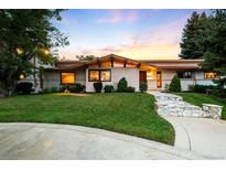 Beautifully landscaped ranch style home with unique architecture and a stone walkway leading to the front door at 6211 E Orchard Dr, Greenwood Village, CO 80111
