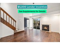 Inviting living room boasts a fireplace, wood floors, and a sliding glass door leading to the outside at 2575 S Syracuse Way # M307, Denver, CO 80231