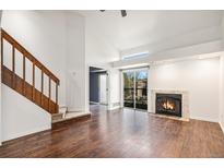 Bright living room features hardwood floors, vaulted ceilings, and a cozy fireplace at 2575 S Syracuse Way # M307, Denver, CO 80231