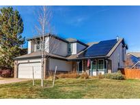 Inviting two-story home with a manicured lawn, solar panels, and an attached two-car garage at 6647 Lynx Cv, Lone Tree, CO 80124