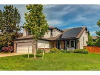 Charming two-story home featuring a manicured lawn, solar panels, and beautiful landscaping at 6647 Lynx Cv, Lone Tree, CO 80124