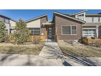 Modern brick home with unique architectural details, landscaped front yard, and stylish curb appeal at 12441 W Virginia Ave, Lakewood, CO 80228