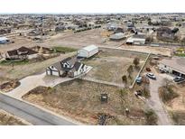 Expansive lot featuring home with attached garages, additional storage building and white perimeter fence at 16665 Kenuil St, Brighton, CO 80603