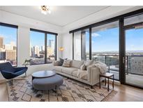 Bright living room featuring large windows with a city view and modern furniture at 1750 Wewatta St # 1720, Denver, CO 80202