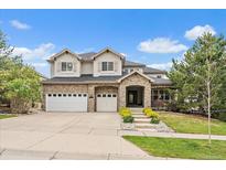Charming two-story home featuring a stone facade, three-car garage, and well-manicured front lawn at 7829 S Coolidge Way, Aurora, CO 80016