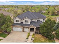 Charming two-story home features a three-car garage, stone accents, and a well-manicured lawn at 7829 S Coolidge Way, Aurora, CO 80016
