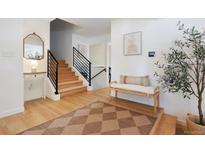 Inviting entryway with wooden floors, staircase, console table, and stylish decor creates a warm welcome at 7629 S Fillmore Way, Centennial, CO 80122