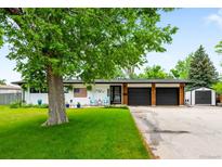 Charming ranch-style home featuring a well-manicured lawn and an attached two-car garage at 7695 S Sheridan Ct, Littleton, CO 80128