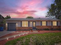Charming single-story home with brick accents, landscaped front yard, and gray-toned garage door at 15642 E Eldorado Dr, Aurora, CO 80013