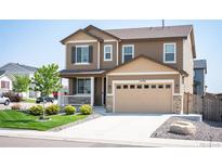 Charming two-story home featuring a two-car garage, covered porch, and well-manicured lawn at 27790 E 9Th Pl, Aurora, CO 80018