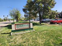 Prairie Green Condominiums entrance sign with landscaping and visitor parking on a sunny day at 9650 Huron St # 23, Thornton, CO 80260