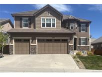 Charming two-story home with a three-car garage and attractive stone and siding exterior at 14193 Double Dutch Cir, Parker, CO 80134