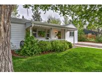 Charming home with beautiful green lawn, landscaped garden and inviting front porch at 2083 W Arbor Ave, Littleton, CO 80120