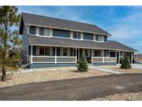 Charming two-story home featuring a welcoming front porch and beautifully landscaped yard at 30484 Chisholm Trl, Elizabeth, CO 80107