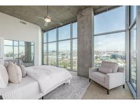Bright bedroom features floor-to-ceiling windows showcasing city views, with modern ceiling fan and neutral tones at 1700 Bassett St # 1106, Denver, CO 80202