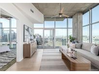 Open concept living room featuring large windows, modern decor, and a balcony at 1700 Bassett St # 1106, Denver, CO 80202
